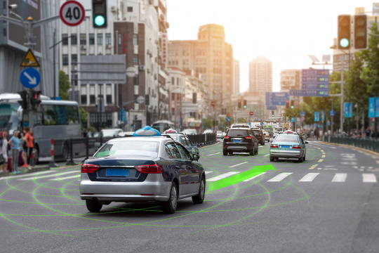 Auf einer Straße befinden sich autonom fahrende Autos. Ein grüner Pfeil markiert den Weg.